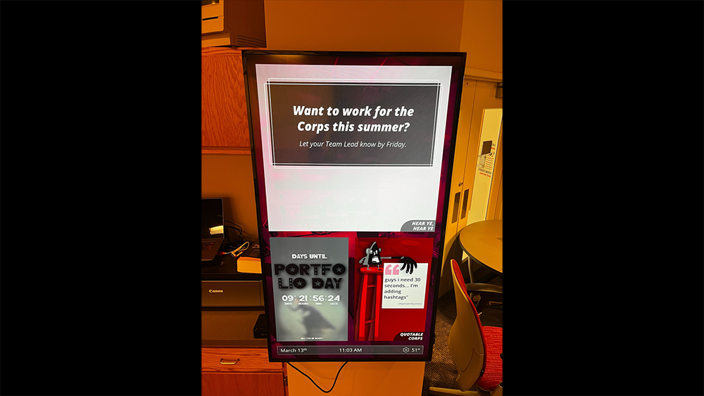 Digital Corps Office TV Board displaying team photos and announcements